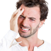 Closeup portrait of upset, stressed out young sick, tired man, handsome sad student having headache, bad day at work, school, isolated on white background. Negative human emotions, facial expressions